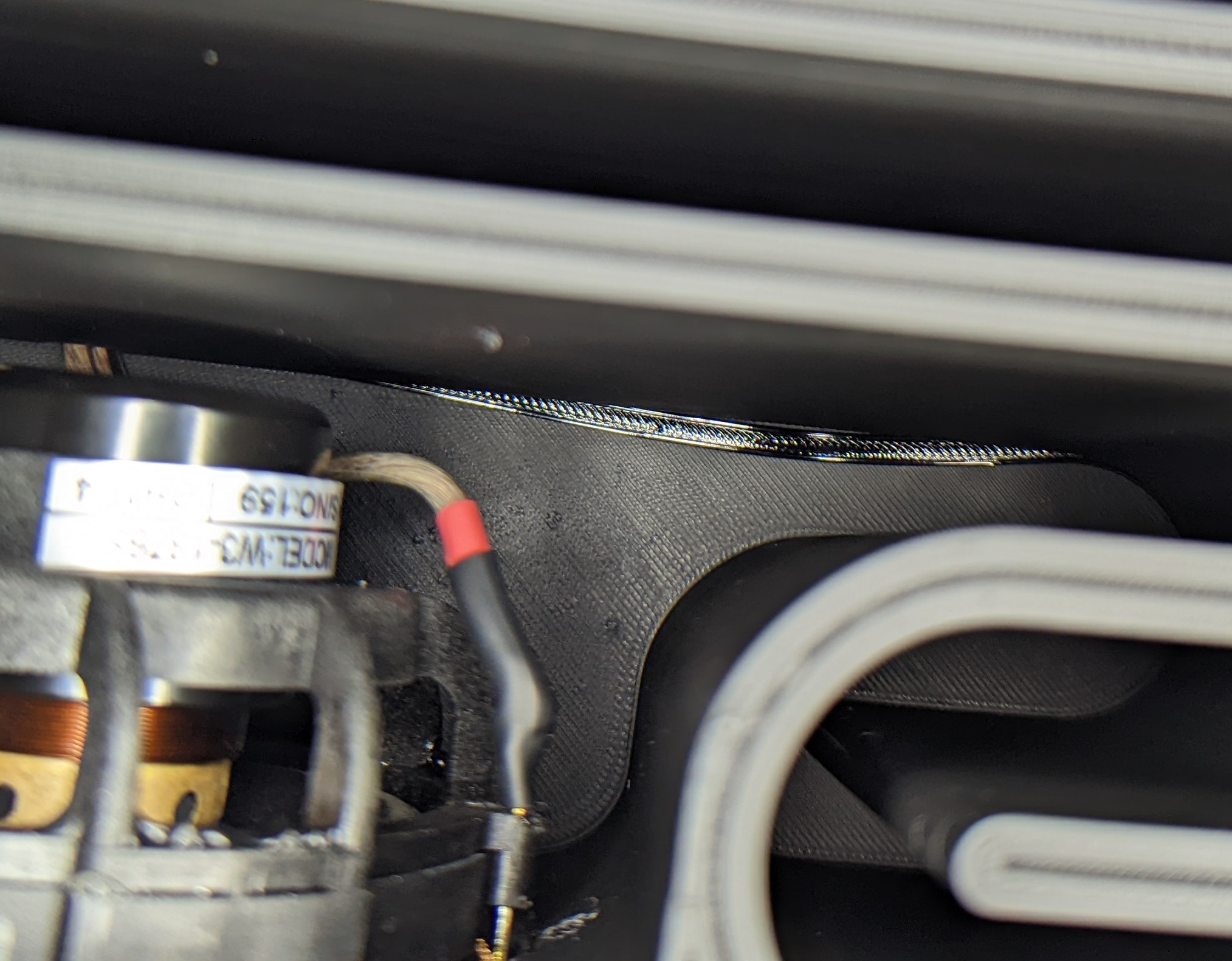 Picture showing close up of subwoofer panel and gasket attached to the subwoofer body. The torque from one of the screws has distorted the gasket material every so slightly.