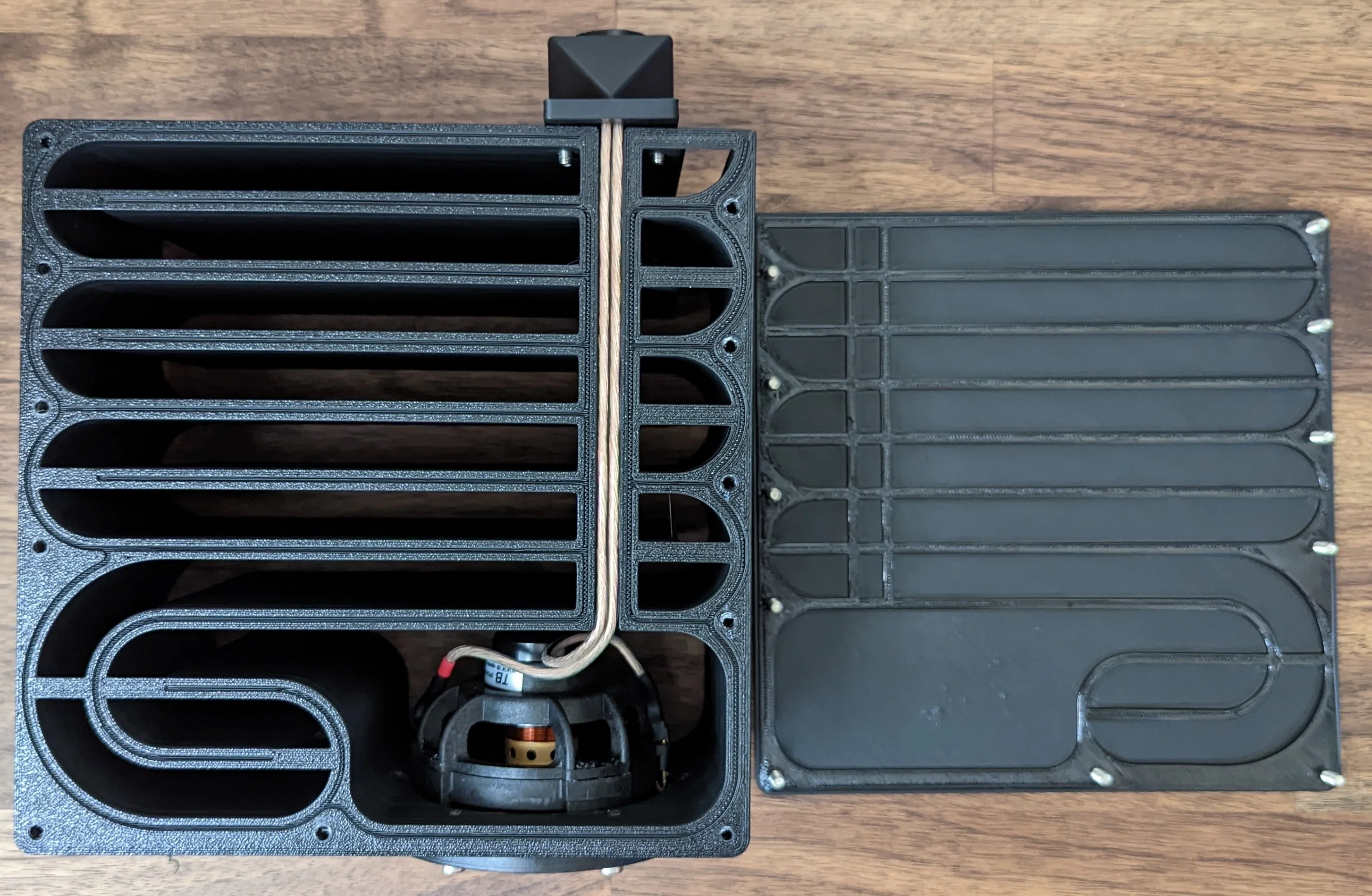 The speaker wire should press-fit into the cable channel more or less sealing it completely.