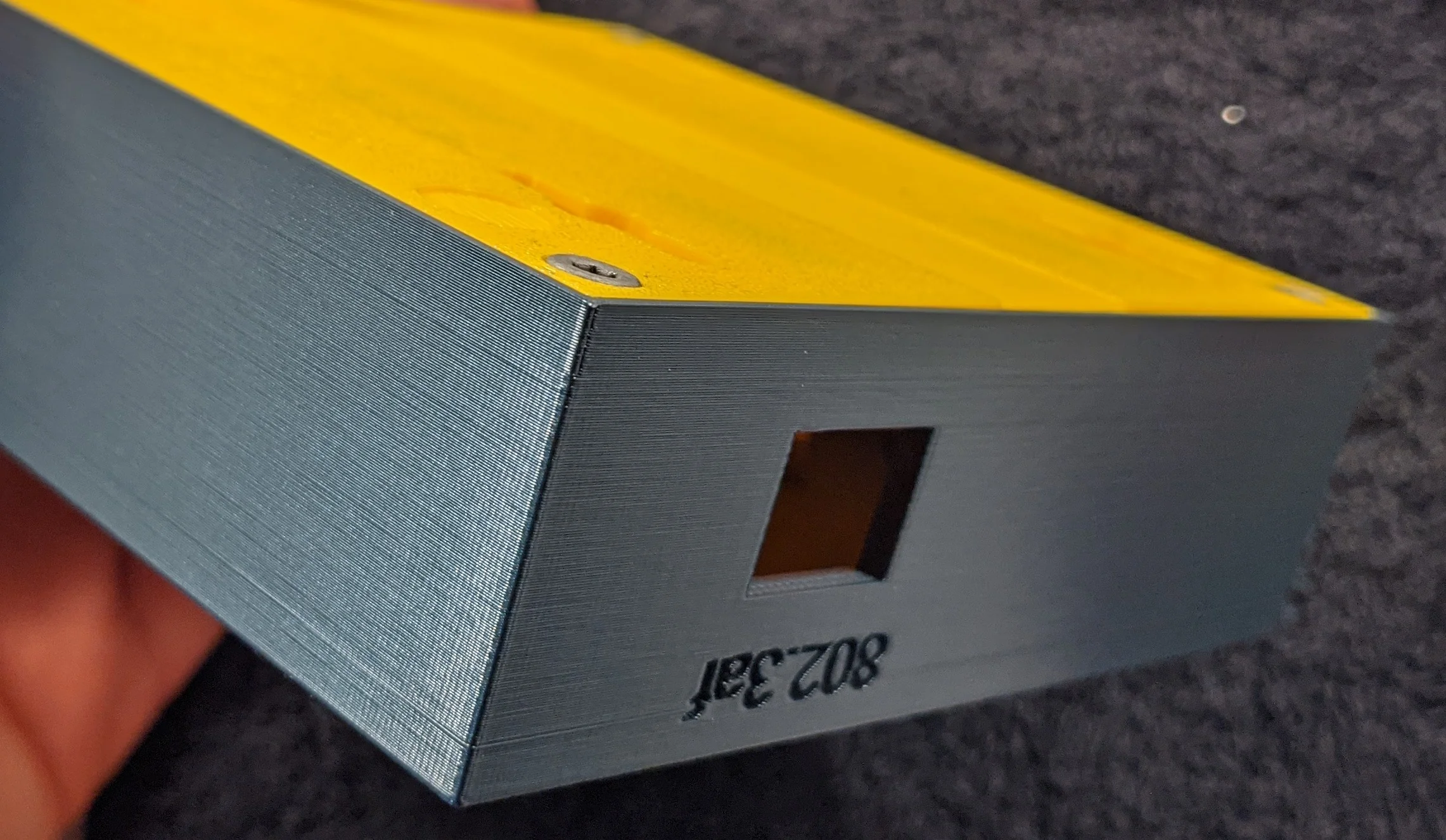 Picture showing assembly detail; the base plate is secured to the enclosure with screws.