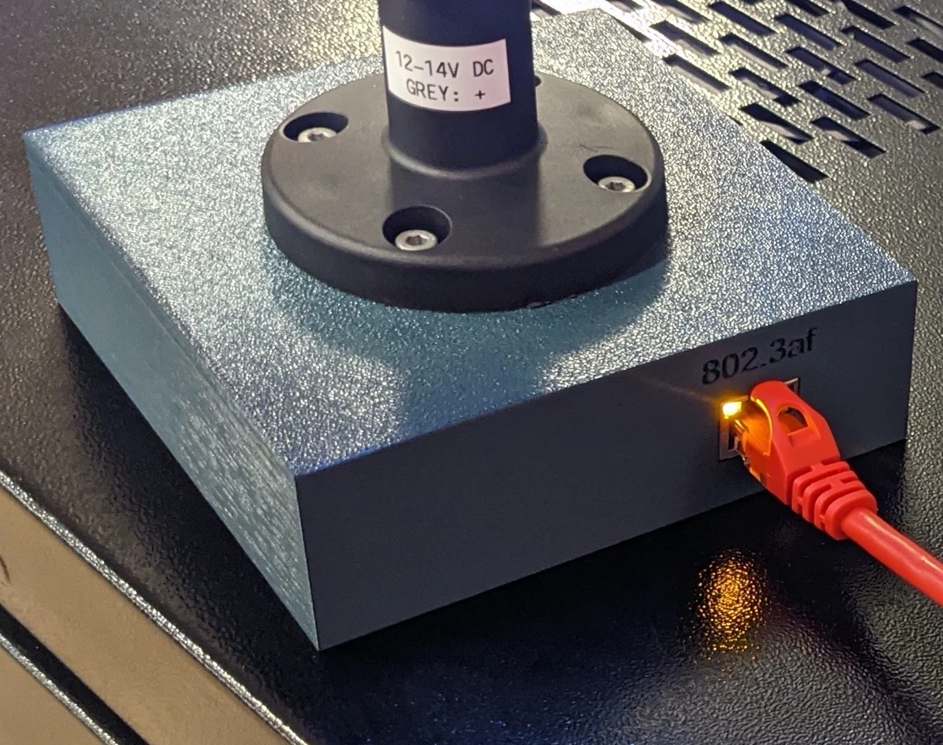 Picture showing assembled light attached to enclosure, focus is on the RJ45 port in the rear.