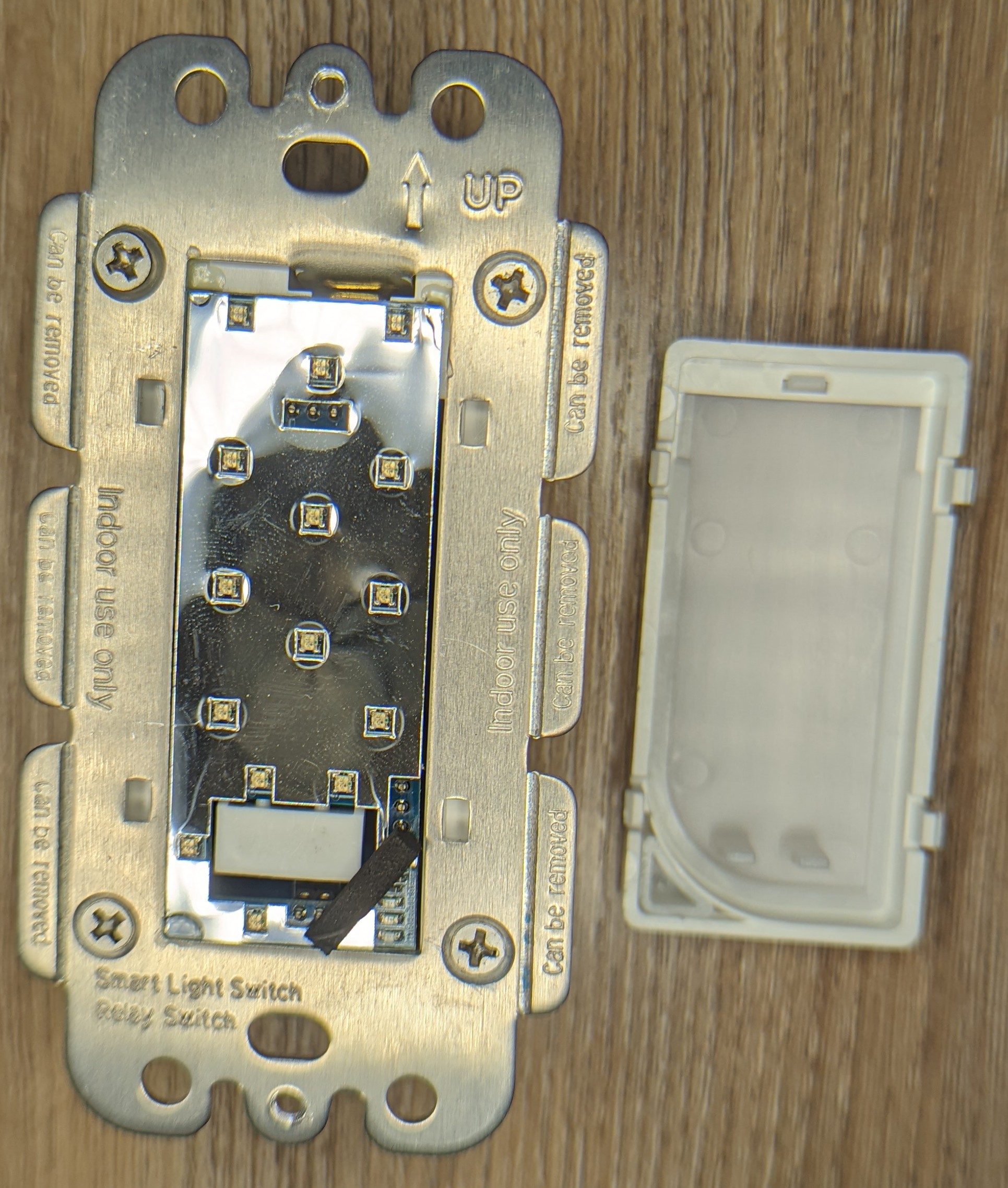 Picture of the switch with no paddle lying next to the paddle. A reflective PCB dotted with RGB leds is visible.