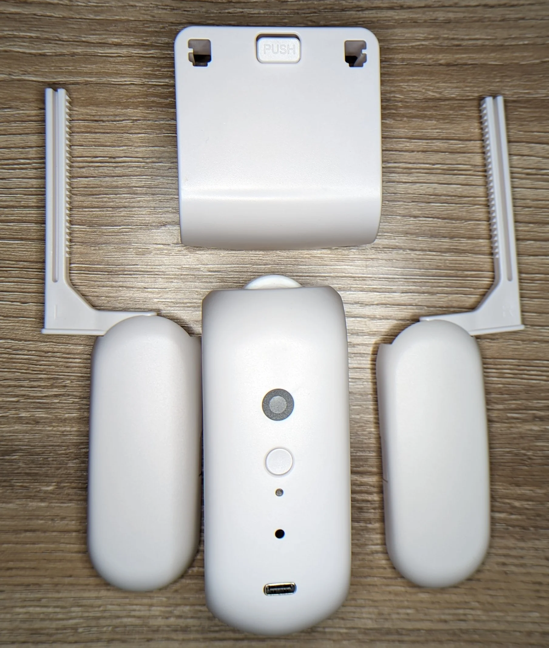 Closeup photo of a curtain robot with the modular curtain rod interface hardware detached along side the main unit.