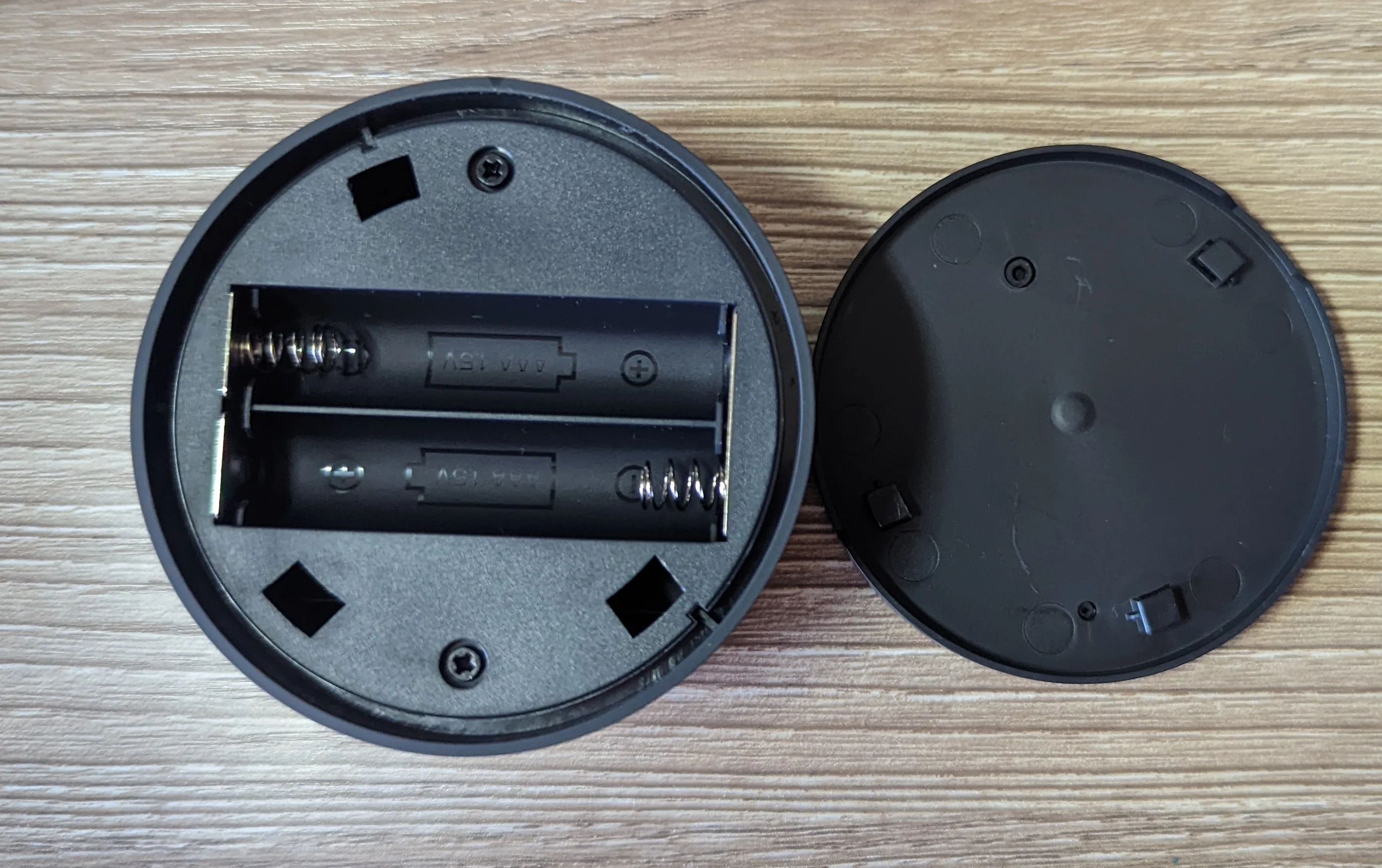 Photo of the remote puck used to control the lamp with its base removed. Two screws are all that hold it together