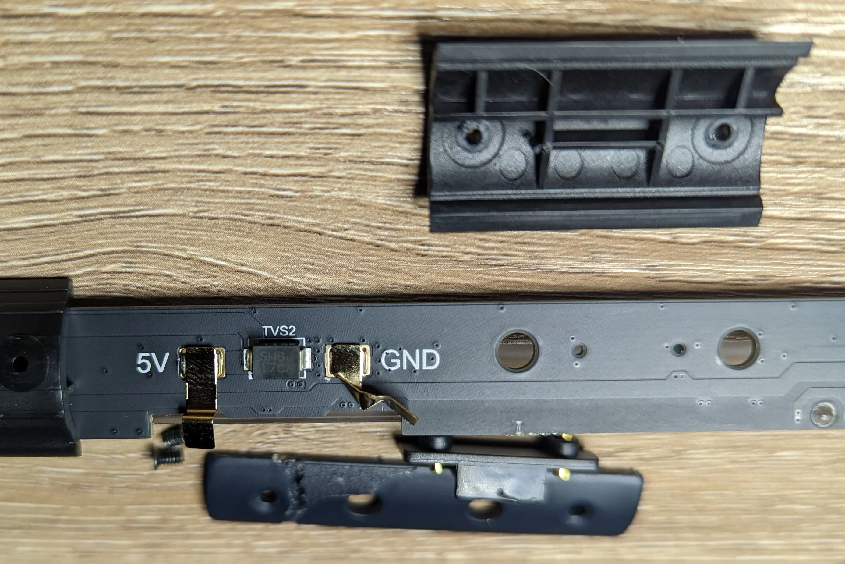 Closeup photo showing damaged components on the main PCB. The components were damaged during initial teardown because of hidden screws.